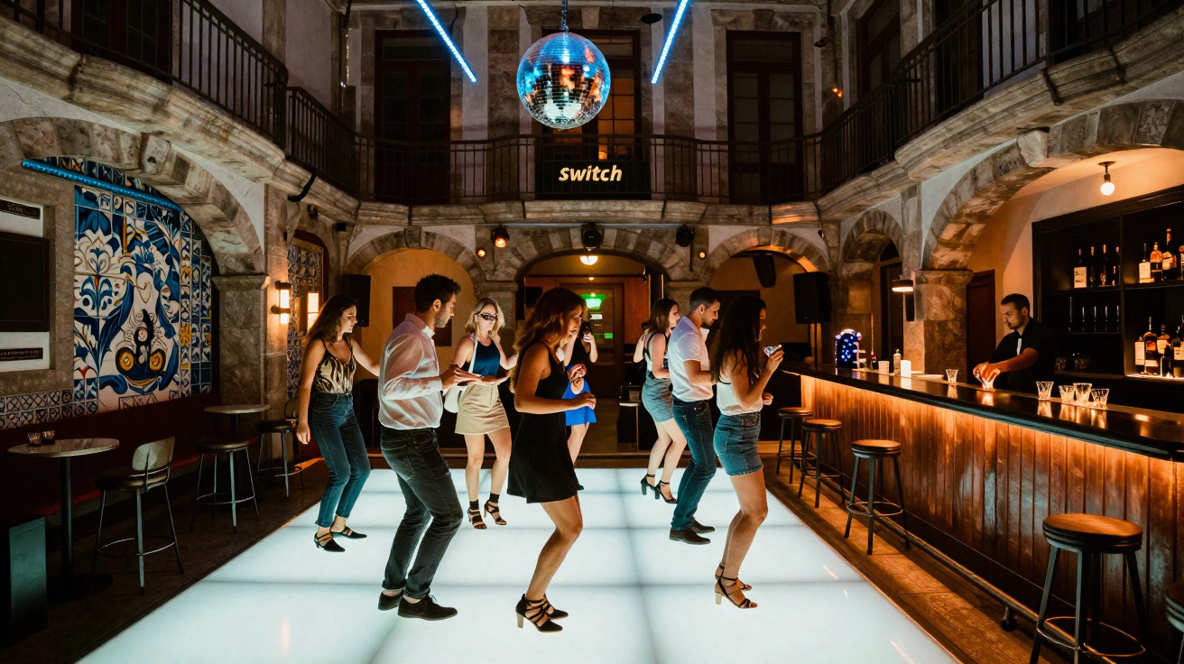 Pessoas a dançar numa discoteca com pista iluminada, bar e decoração em azulejos tradicionais portugueses.